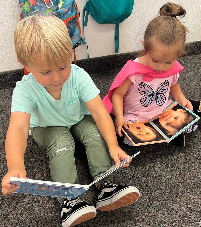 Two cute kids reading books. Awww.