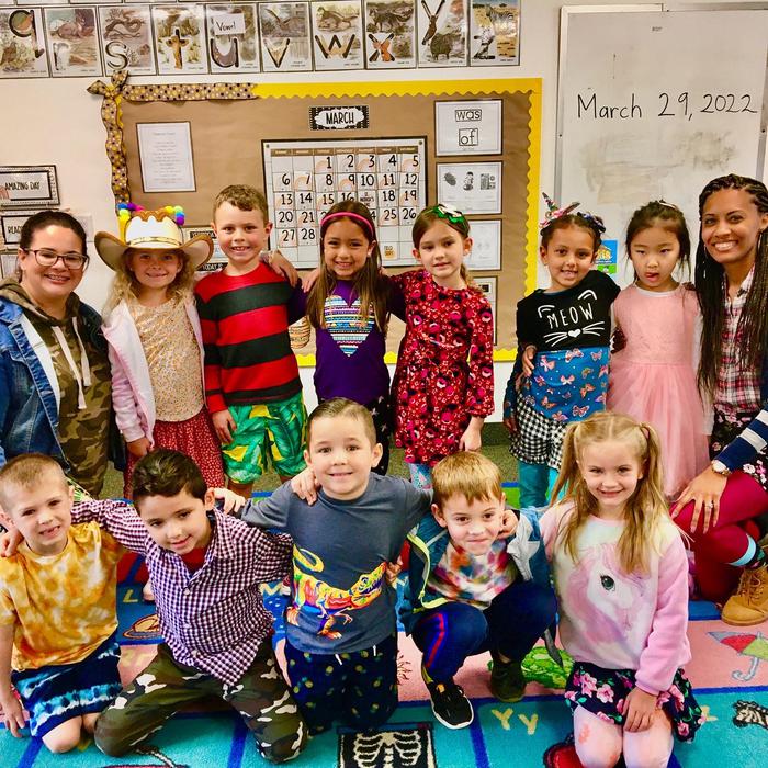 A group of kindergartners taking a photo in a classroom