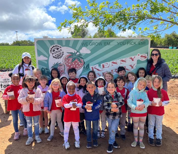 A group photo of children at a strawberry patch