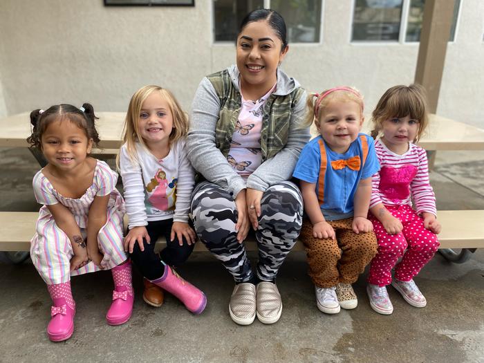 A group photo of a teacher with four toddlers. it's such a cute photo!