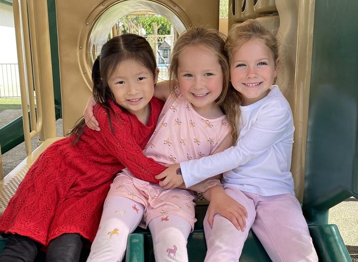 A photo of three little girls smiling