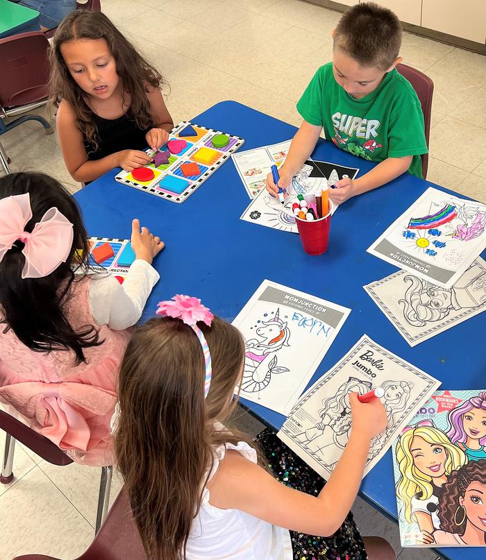 A group of kindergartners playing with arts and crafts.