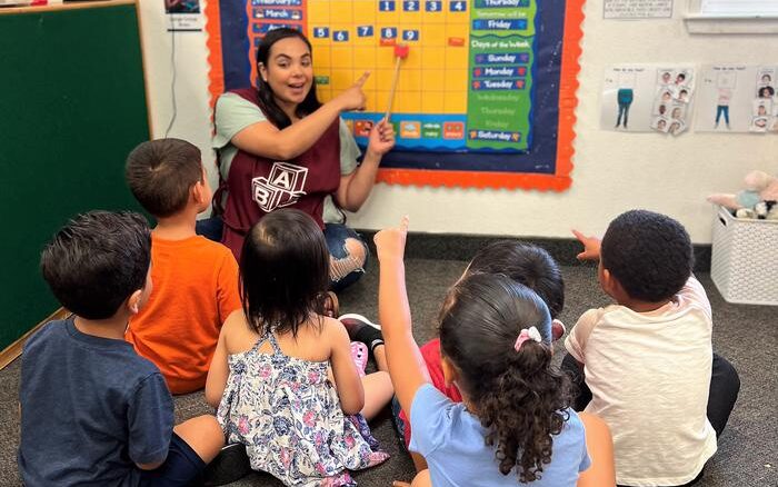 A teacher teaching a group of kindergartners about calendars